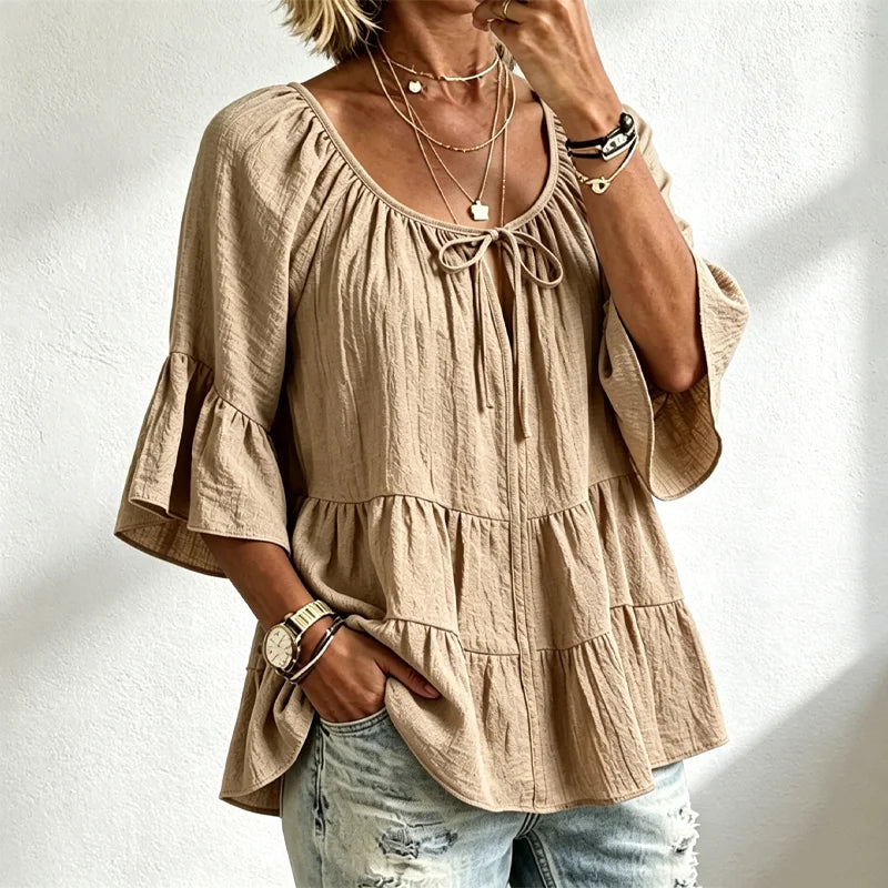 Elegantna ženska bluza s volanima i vezicom oko dekoltea, zvonasti rukavi do tri četvrtine, teksturirana košulja u boho-chic stilu, ležerni peplum uzorak