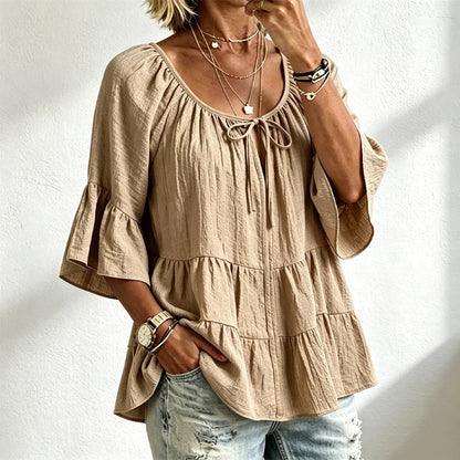 Elegantna ženska bluza s volanima i vezicom oko dekoltea, zvonasti rukavi do tri četvrtine, teksturirana košulja u boho-chic stilu, ležerni peplum uzorak