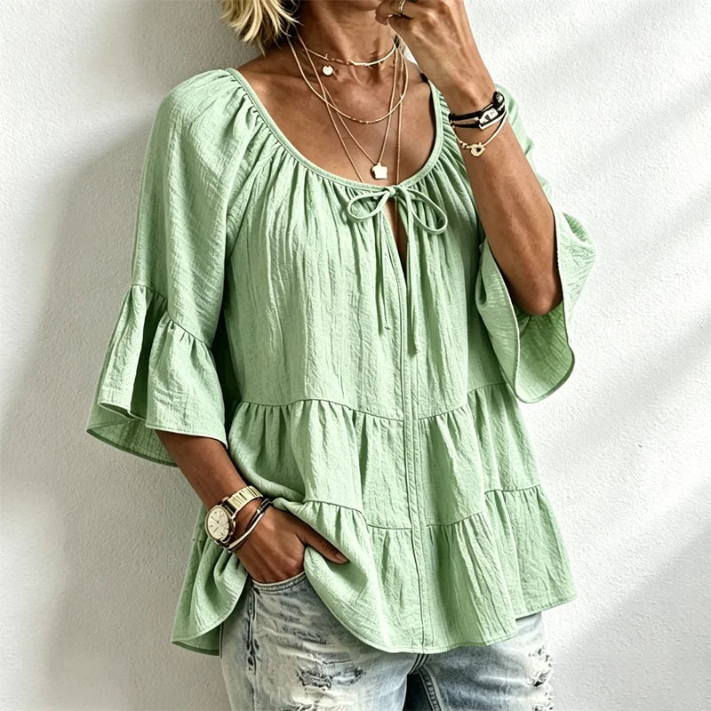 Elegantna ženska bluza s volanima i vezicom oko dekoltea, zvonasti rukavi do tri četvrtine, teksturirana košulja u boho-chic stilu, ležerni peplum uzorak