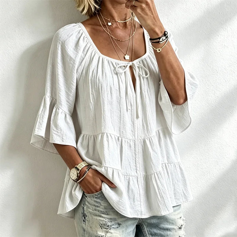 Elegantna ženska bluza s volanima i vezicom oko dekoltea, zvonasti rukavi do tri četvrtine, teksturirana košulja u boho-chic stilu, ležerni peplum uzorak