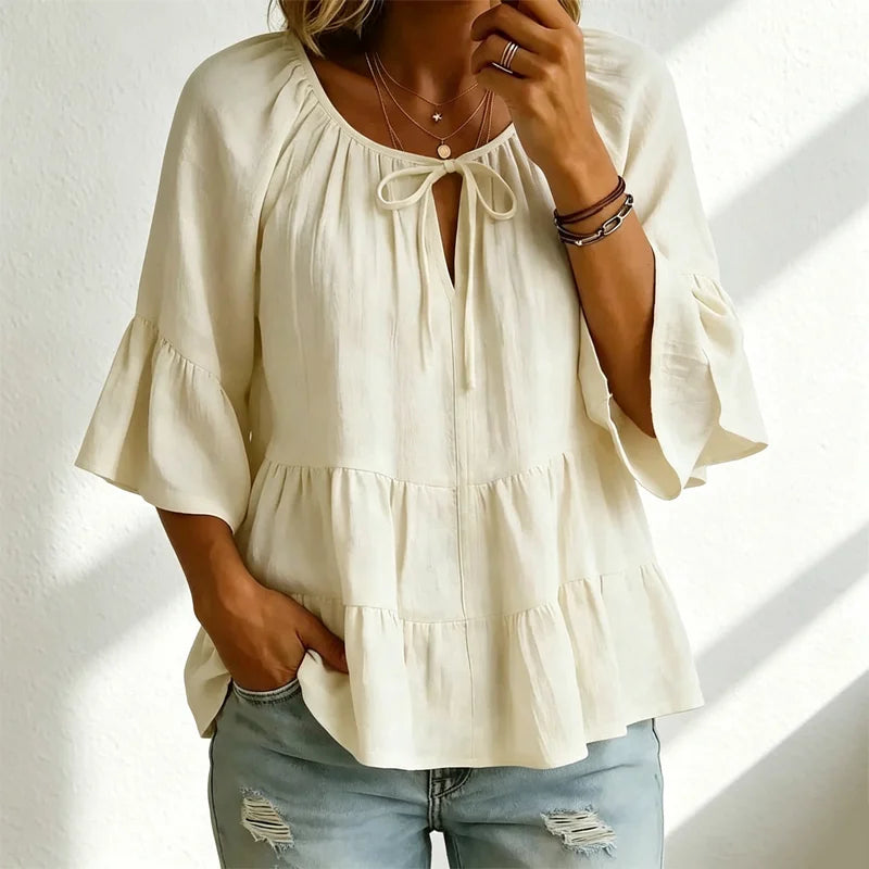 Elegantna ženska bluza s volanima i vezicom oko dekoltea, zvonasti rukavi do tri četvrtine, teksturirana košulja u boho-chic stilu, ležerni peplum uzorak