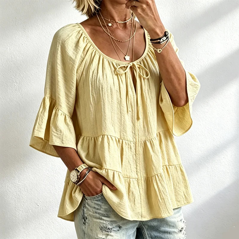 Elegantna ženska bluza s volanima i vezicom oko dekoltea, zvonasti rukavi do tri četvrtine, teksturirana košulja u boho-chic stilu, ležerni peplum uzorak